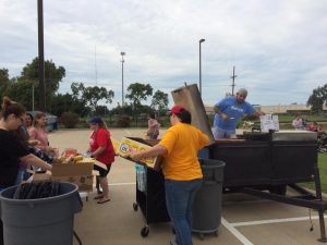 Alorica staff cooking and serving hot dogs