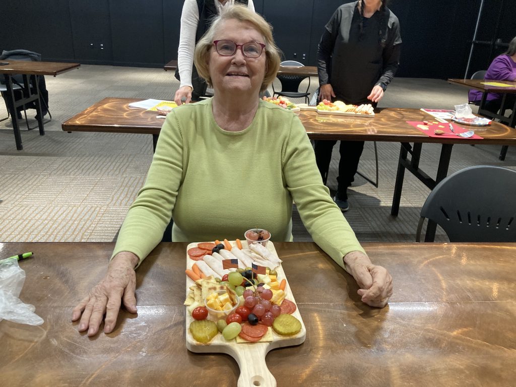 Senior woman with charcuterie board.